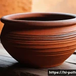 Home 23 수제 도자기와 기계 생산 비교 - A close-up of a handcrafted clay pot with visible irregularities and unique textures, showcasing the...