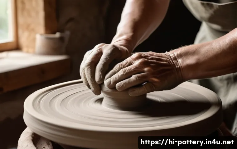 도자기 만들기 체험 후기 - A close-up scene of a person&rsquo;s hands shaping soft, moist clay on a spinning pottery wheel, capturing...